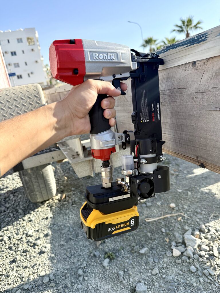 Nail gun held in the mini compressor bracket, running on a 20V battery