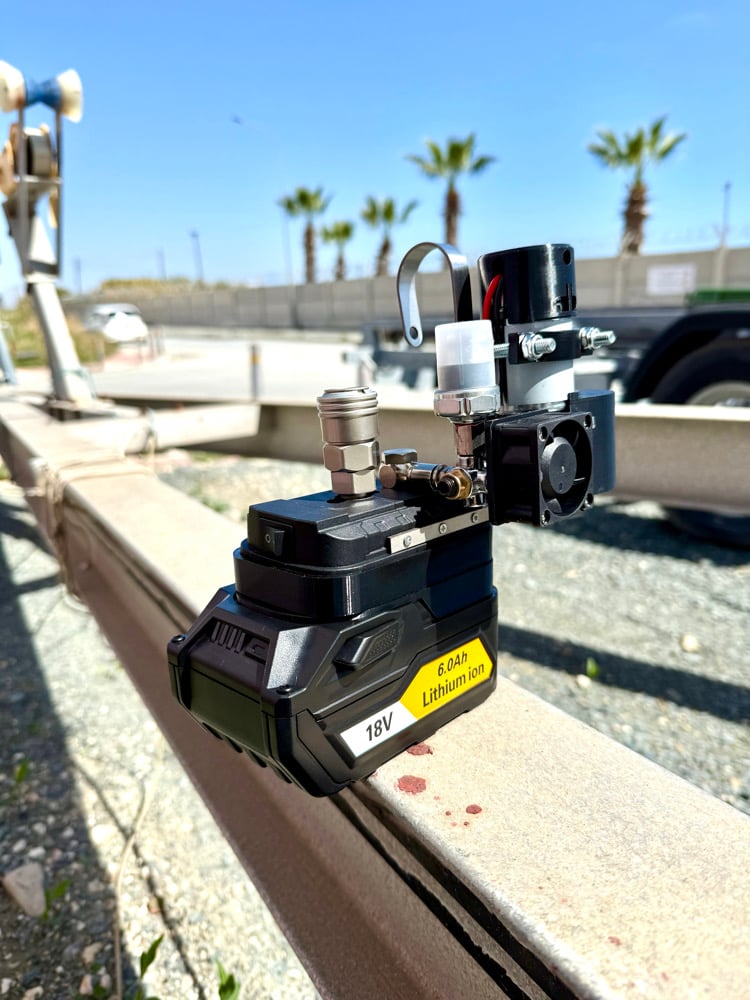 Cordless mini compressor on a black 18V 4.0Ah battery