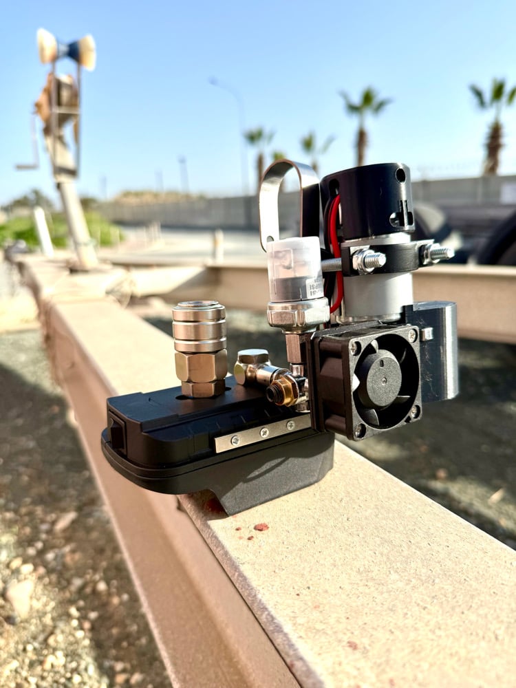 Cordless mini compressor and battery adapter base on a concrete wall