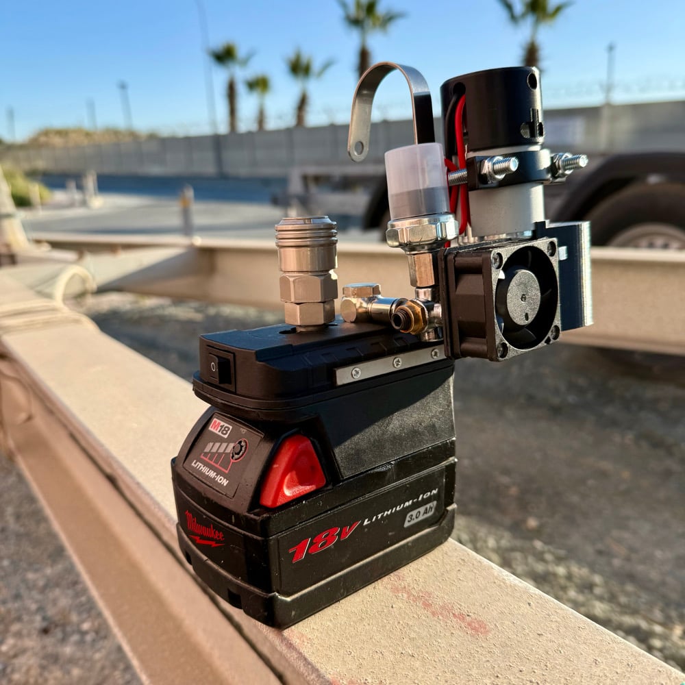 Cordless mini compressor on a red 18V lithium-ion battery